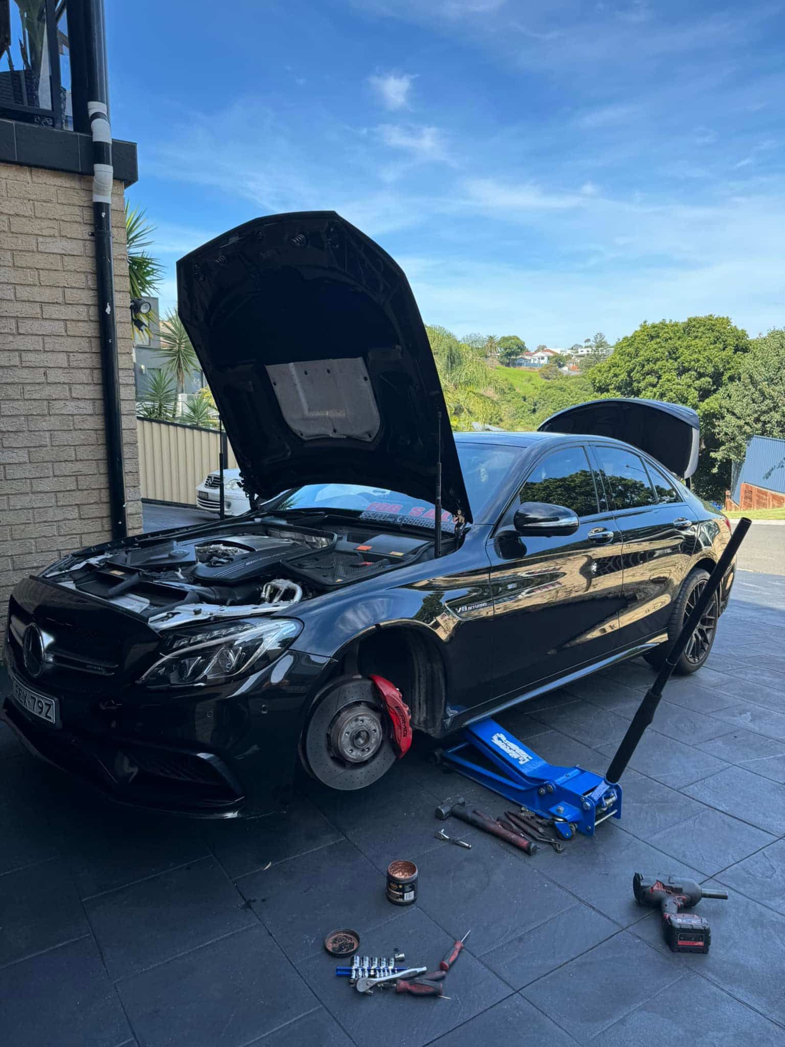 A Black Car with The Hood up Is Sitting on A Jack — BEB Automotive In Berkeley, NSW