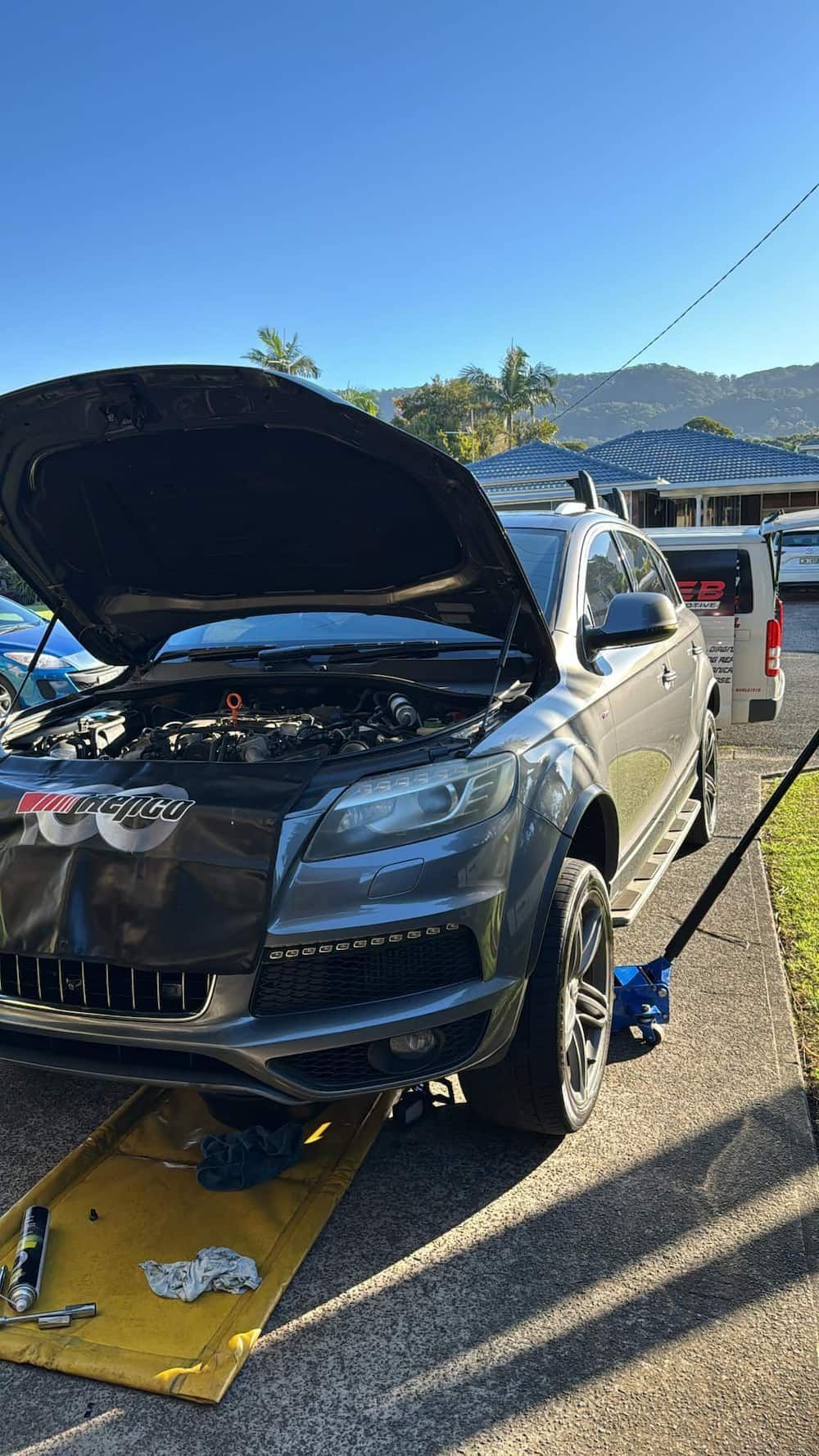 A Car with Its Hood Open Is Sitting on A Yellow Mat on The Side of The Road — BEB Automotive In Berkeley, NSW