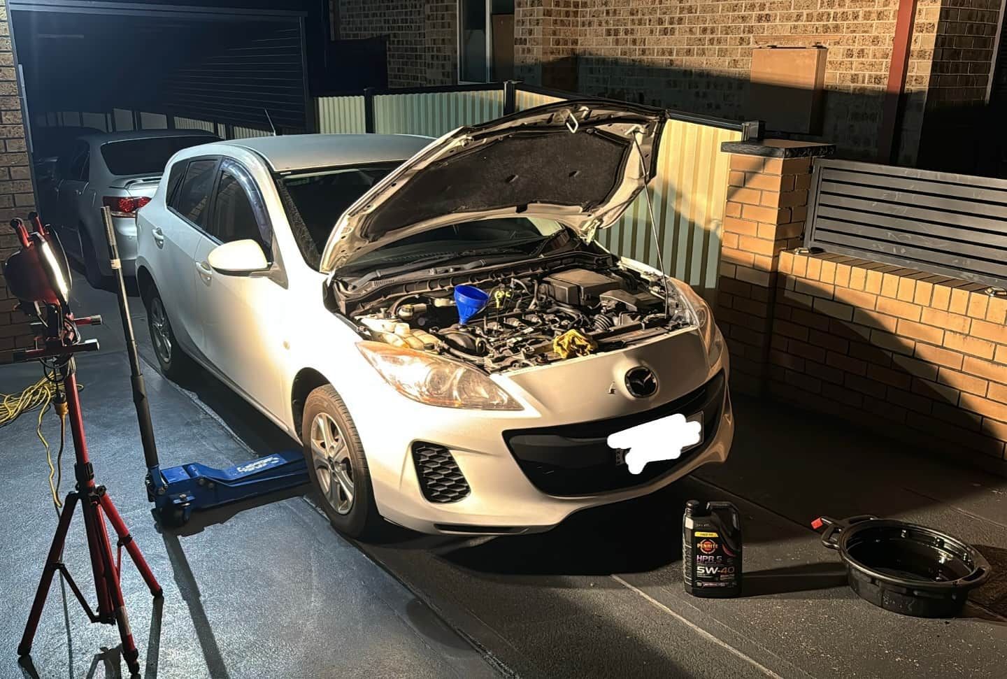 A White Car with The Hood Open Is Parked in A Garage — BEB Automotive In Shellharbour, NSW
