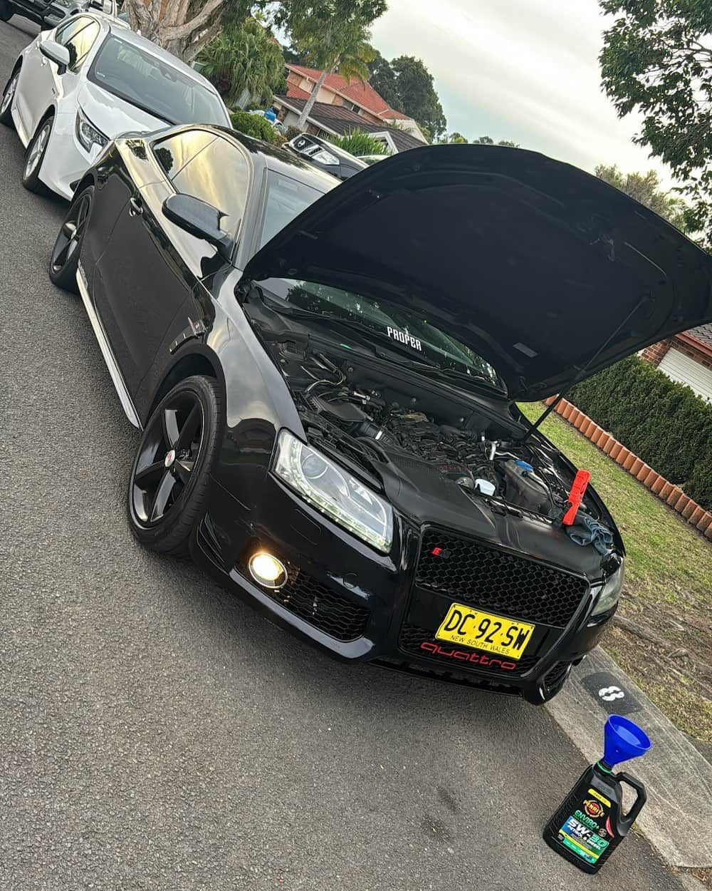 A Black Car with The Hood up Is Parked on The Side of The Road — BEB Automotive In Campbelltown, NSW