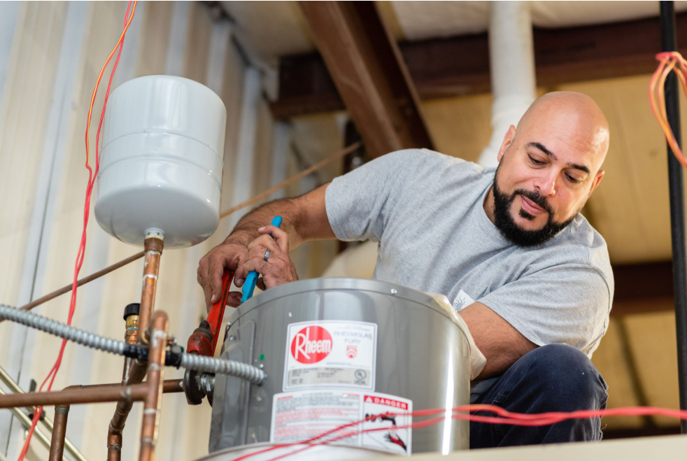 Water Heater Repairs — Man Working On Water Heater in Tinley Park, IL