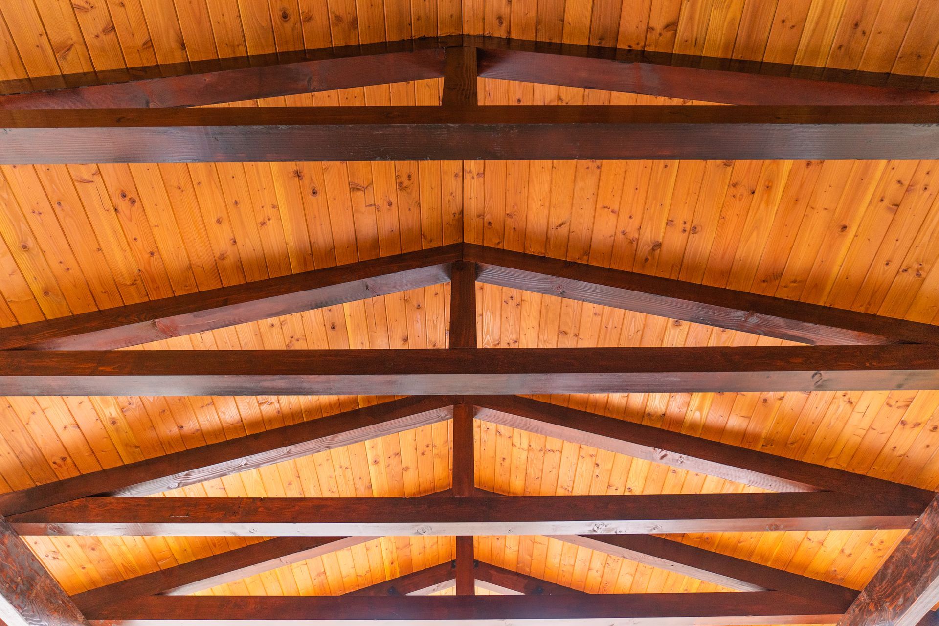 A close up of a wooden ceiling with wooden beams.