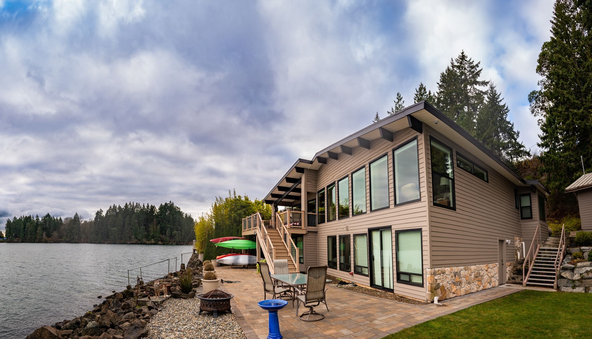 A large house is sitting on the shore of a lake.