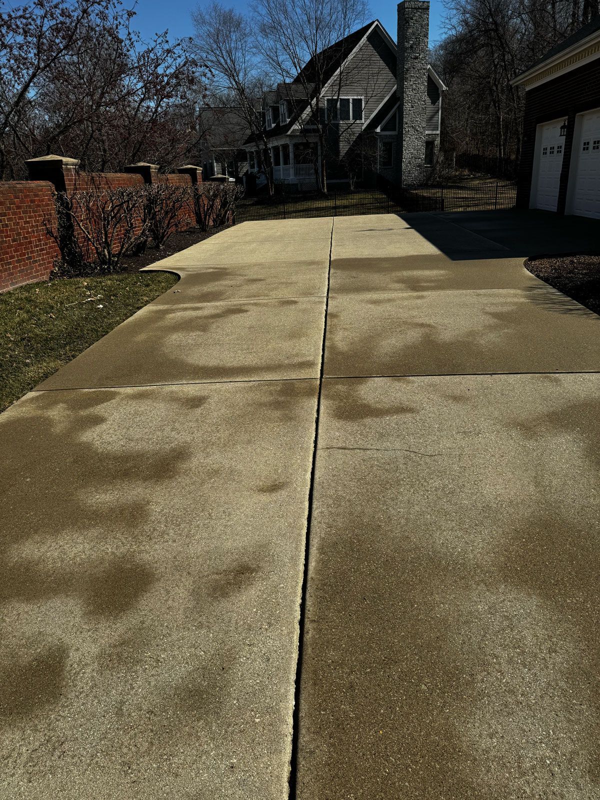 A concrete driveway with a house in the background.