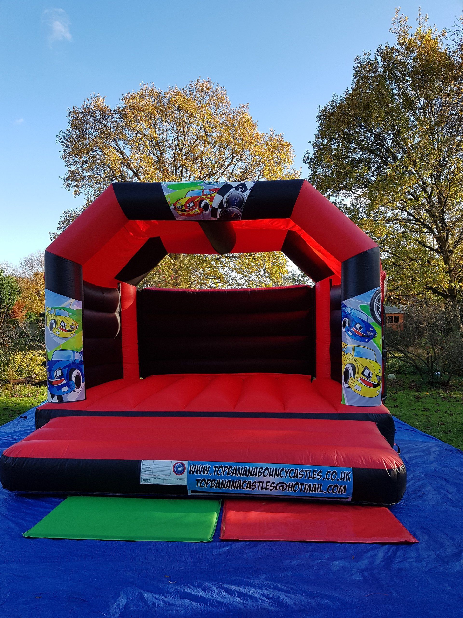 red and black adult bouncy castle with race car artwork