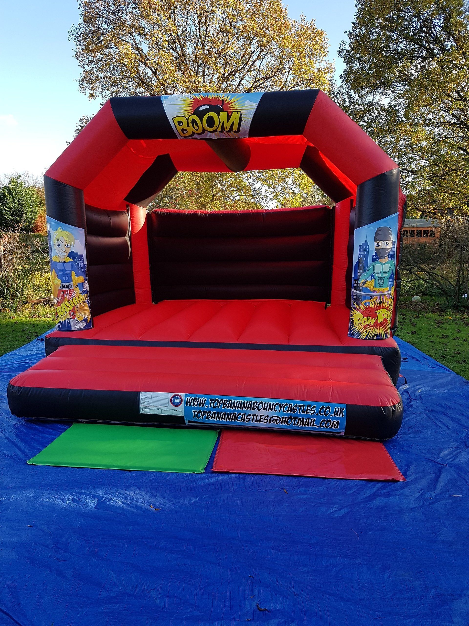 red and black adult bouncy castle with super hero artwork