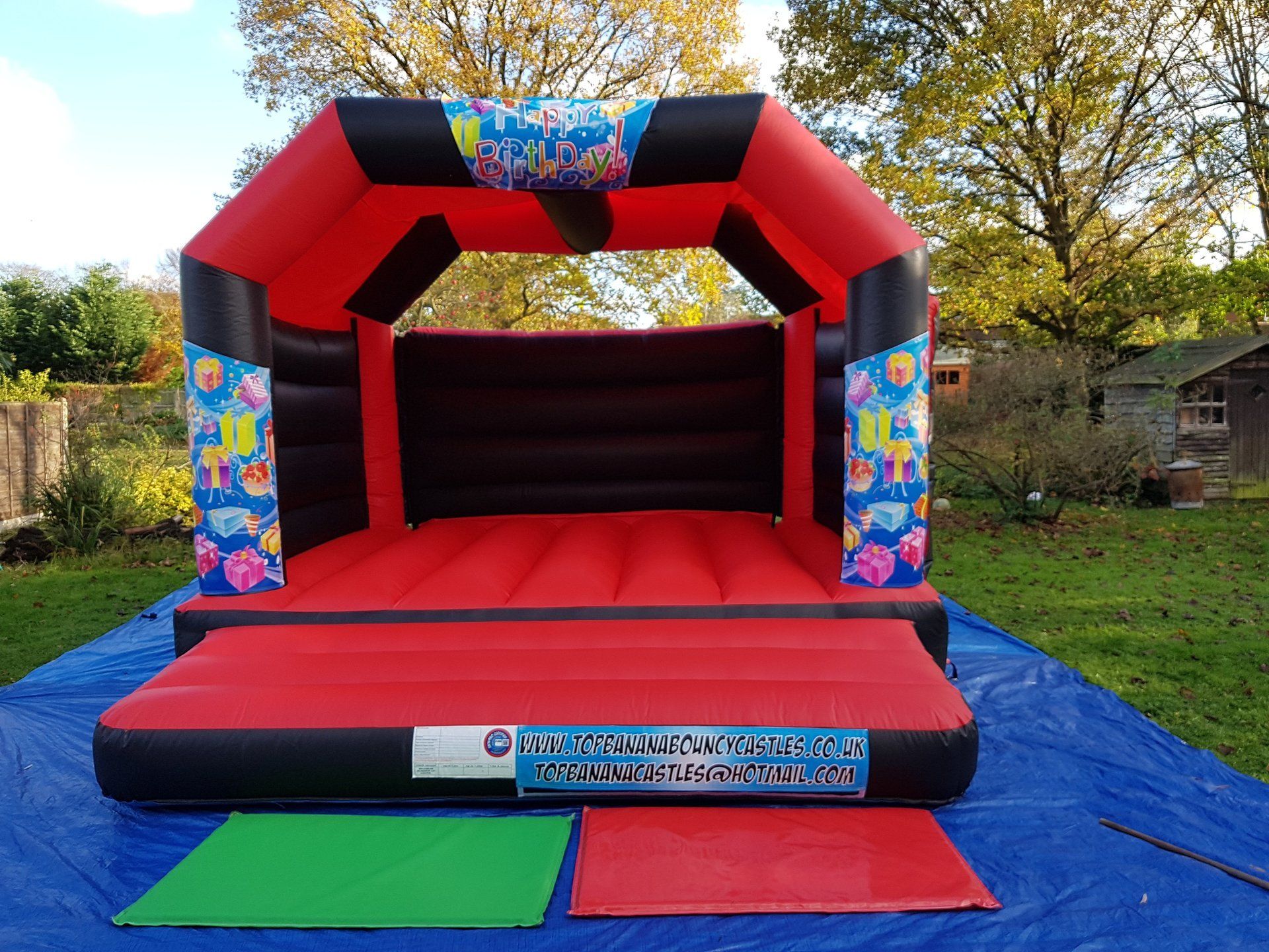 red and black adult bouncy castle with birthday artwork