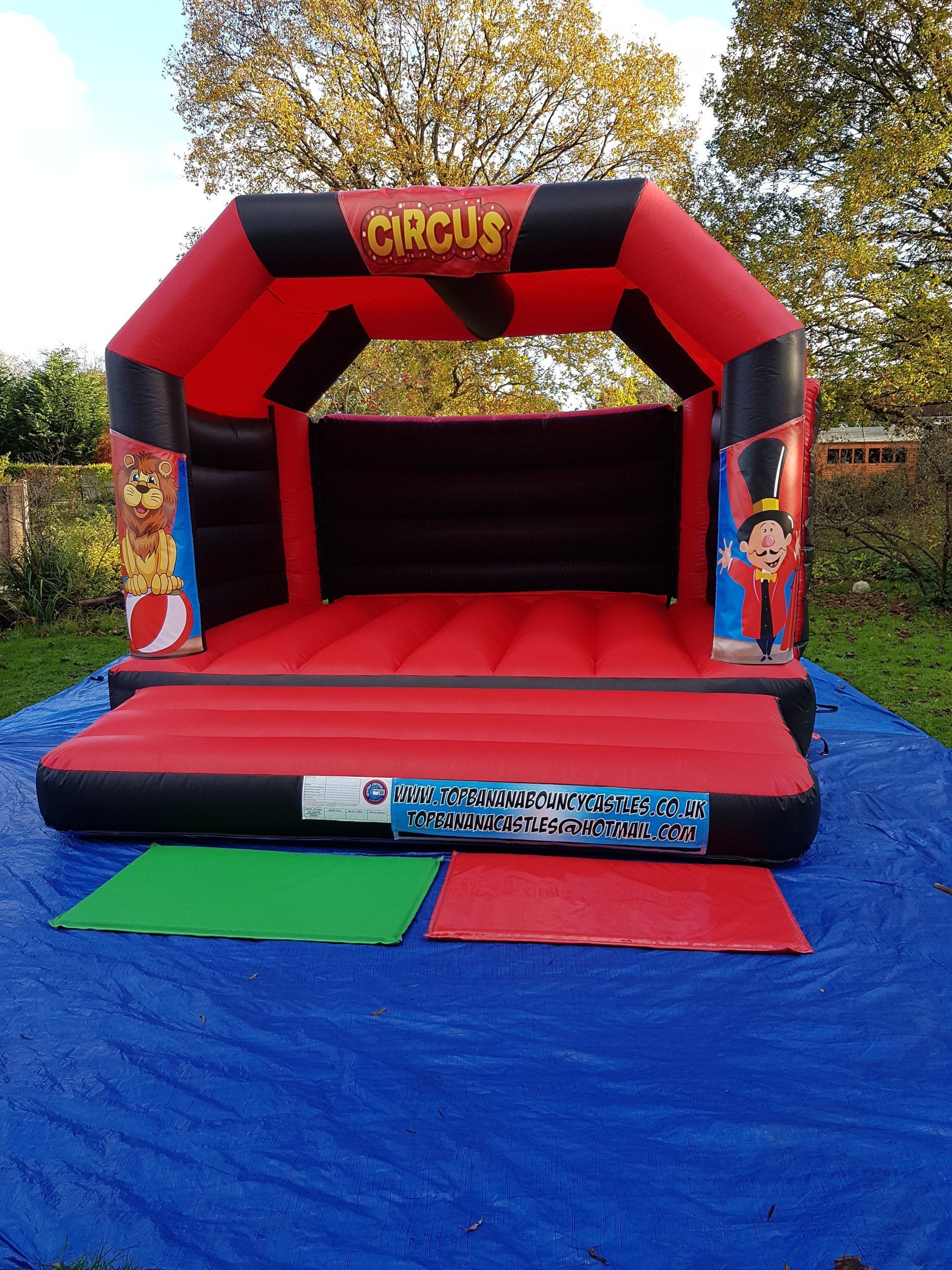 red and black adult bouncy castle with circus artwork
