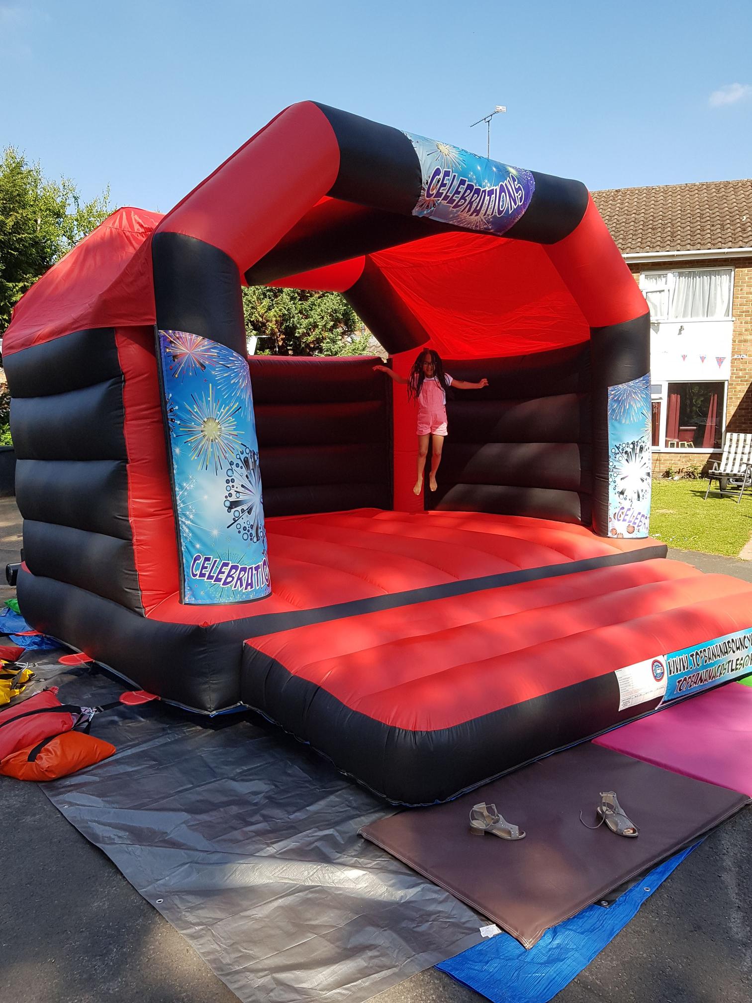 adult red and black bouncy castle with celebration theme