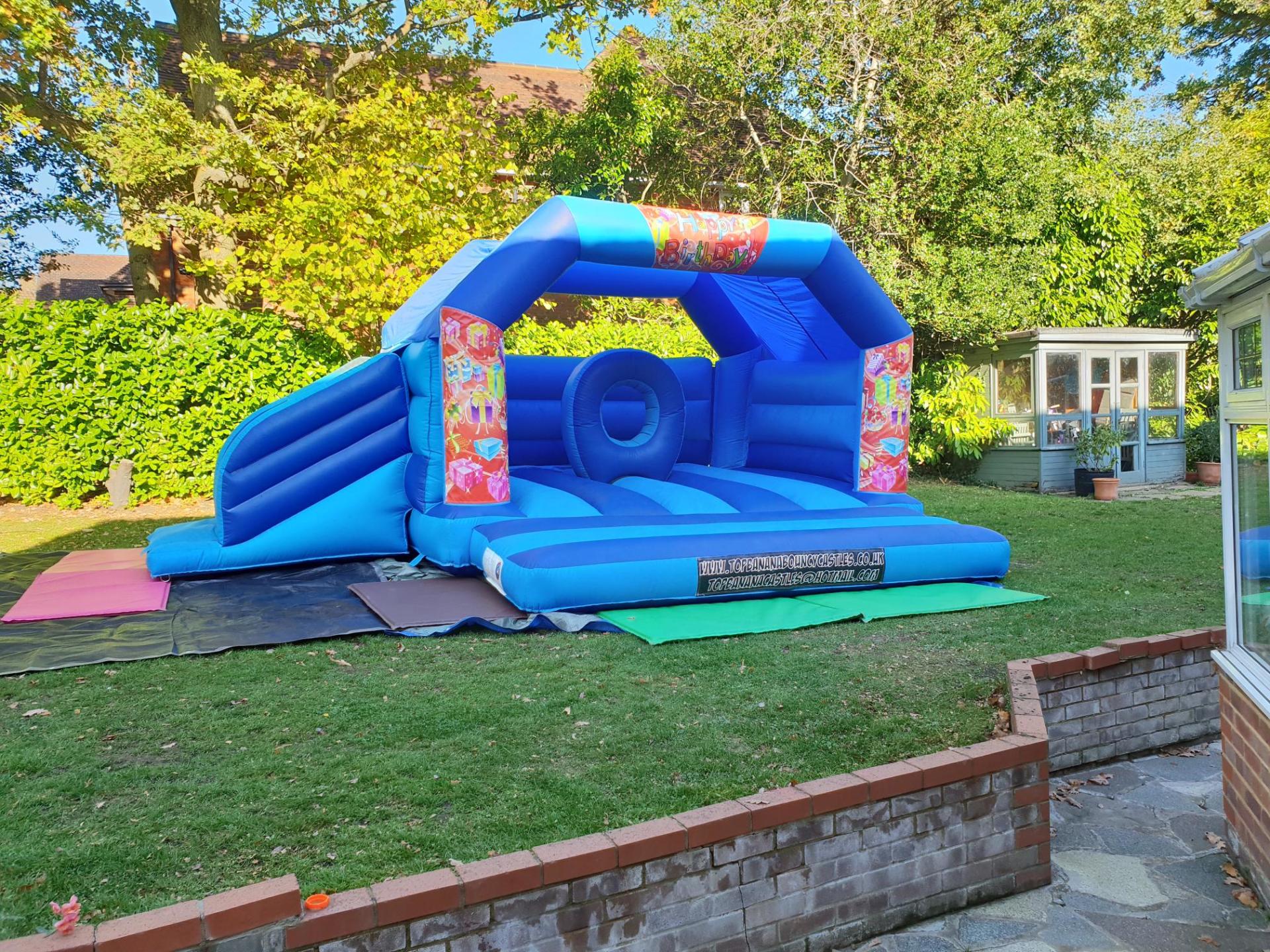 slide combo bouncy castle with birthday theme in large garden