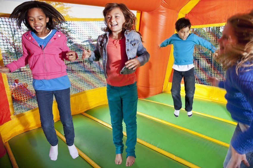 four children enjoying a bouncy castle