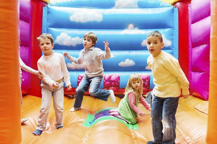 children of different ages enjoying a bouncy castle