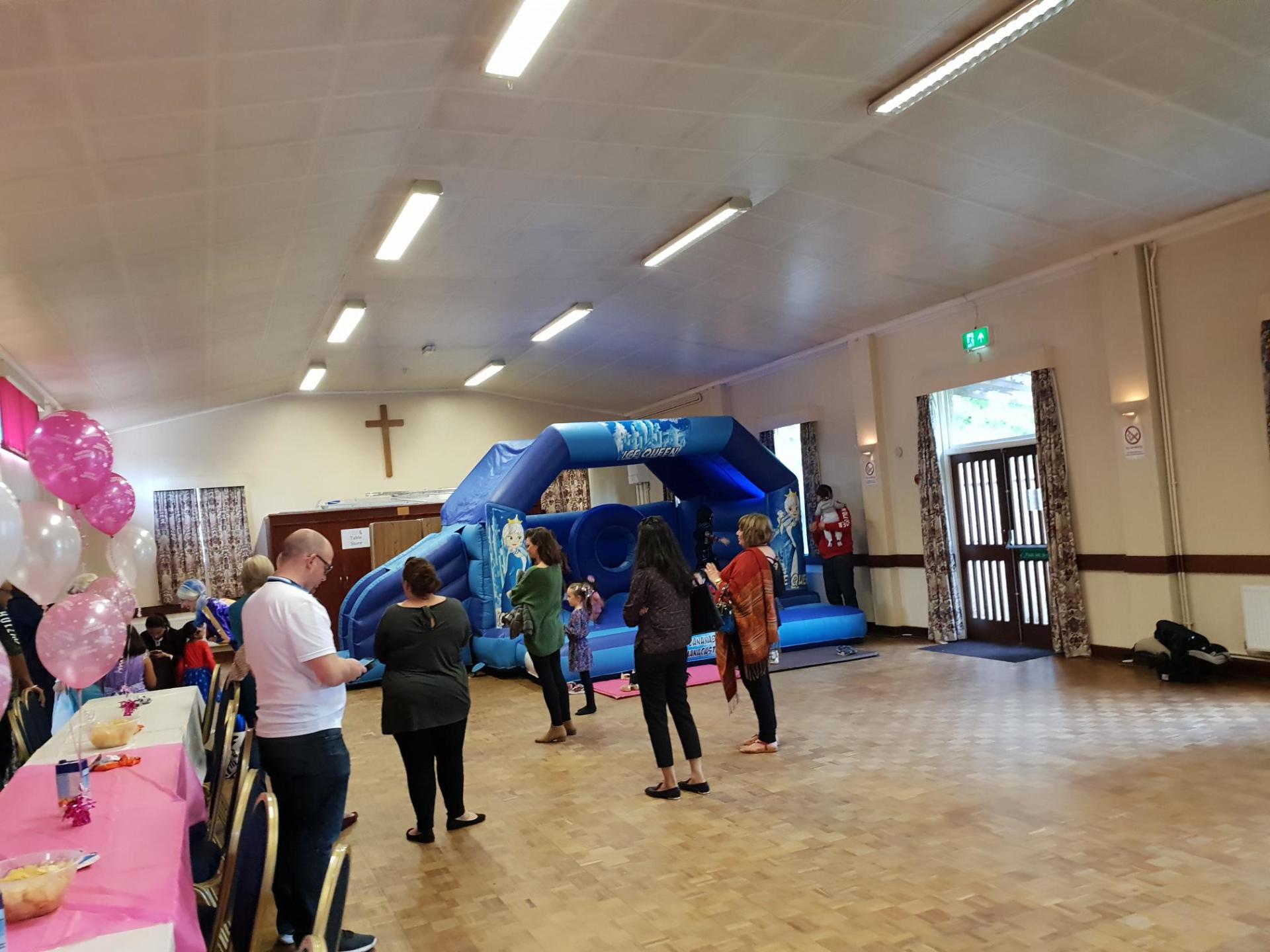 large slide combo bouncy castle in a village hall