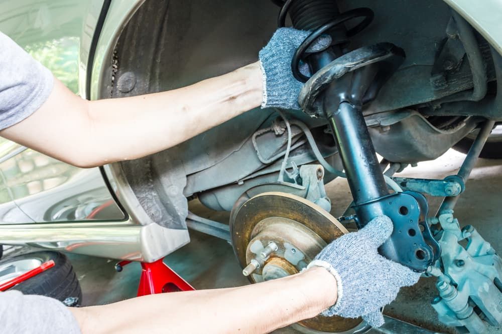 A Man Is Working on The Suspension of A Car — Palmerston Auto Clinic in Yarrawonga, NT