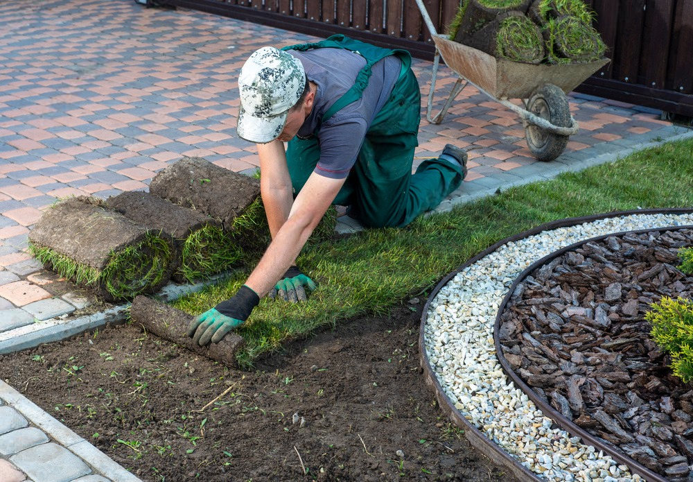 a man is kneeling in the dirt and rolling grass