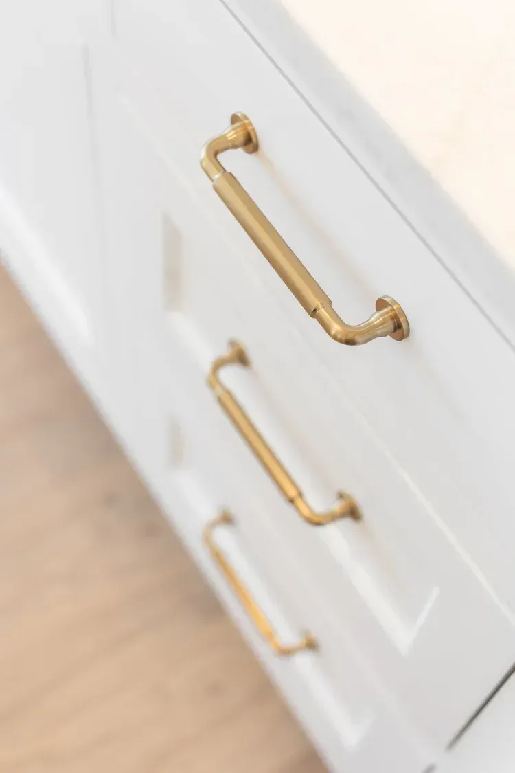 White dresser drawers with gold handles viewed at an angle