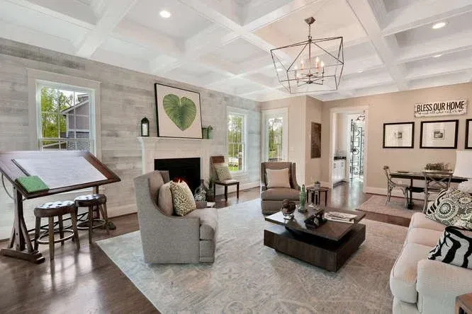 Bright modern living room with gray furniture, fireplace, coffee table, and large windows