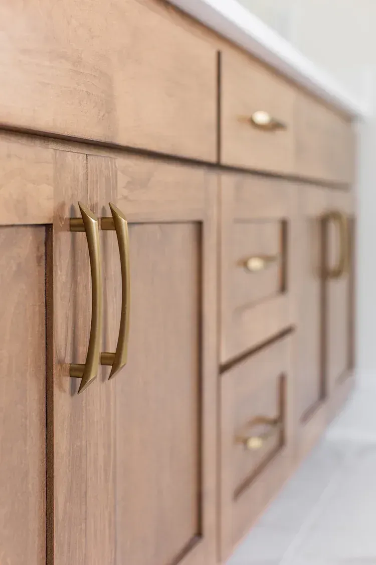 Wooden kitchen cabinets with brass handles, viewed from a low angle
