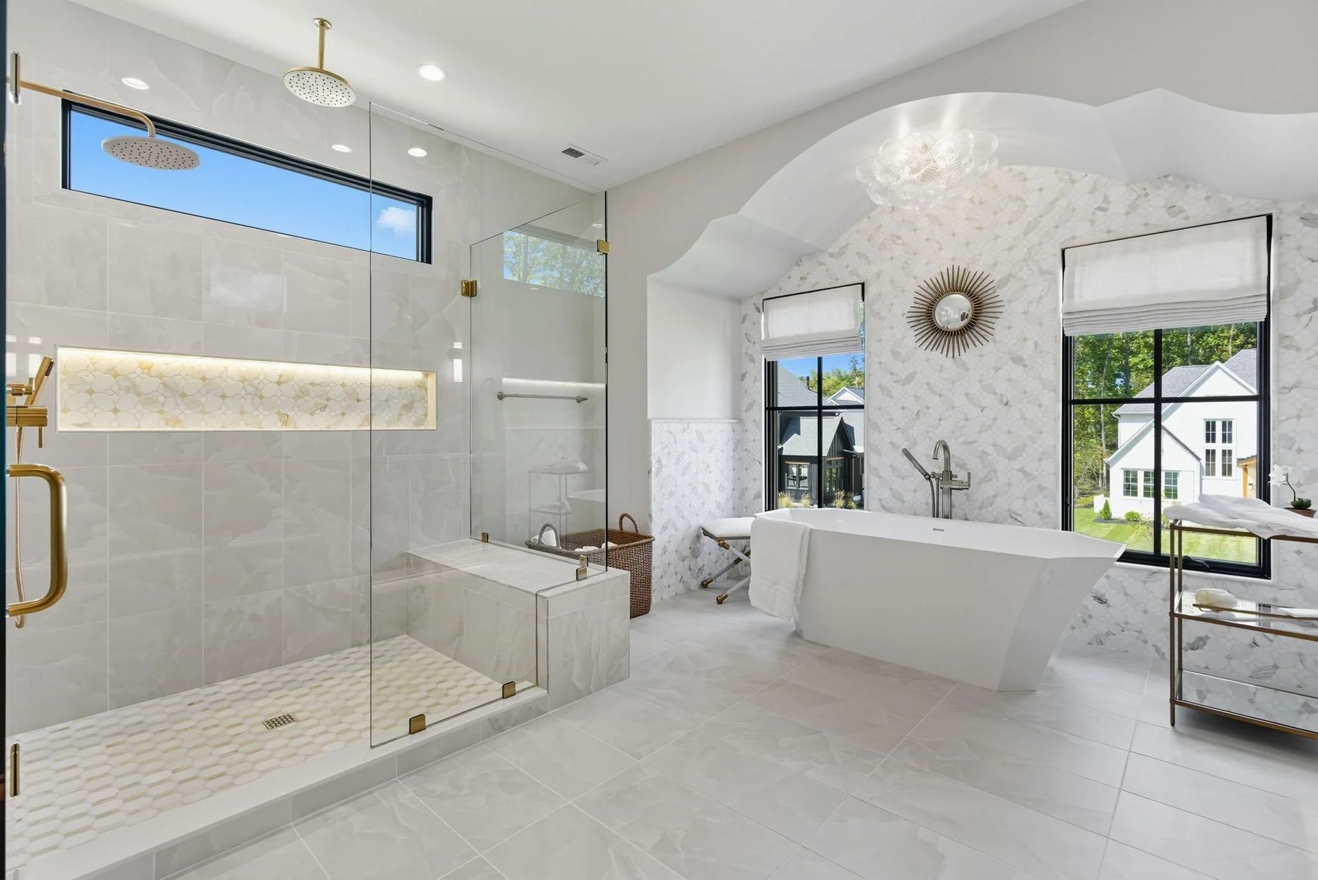 A luxurious modern bathroom with a white marble walk-in shower, a freestanding soaking tub, and large windows.