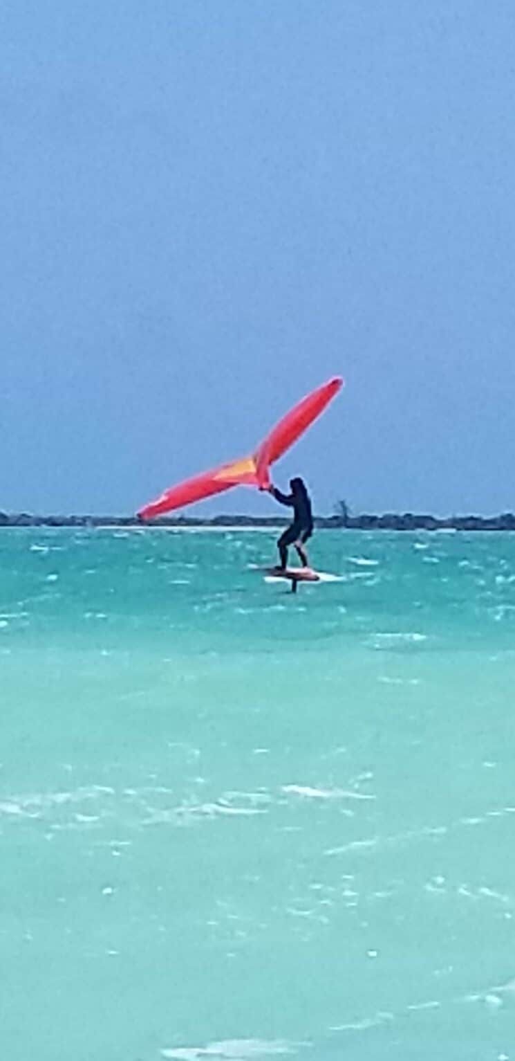 A person is flying through the air on a surfboard in the ocean.