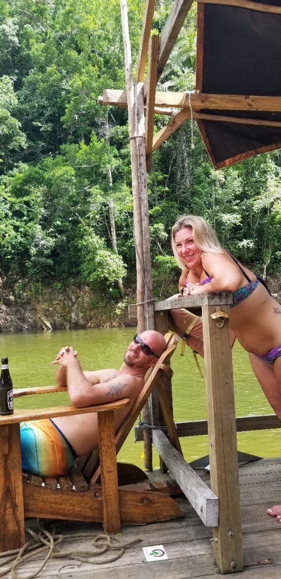 A man is laying in a chair next to a woman in a bikini.