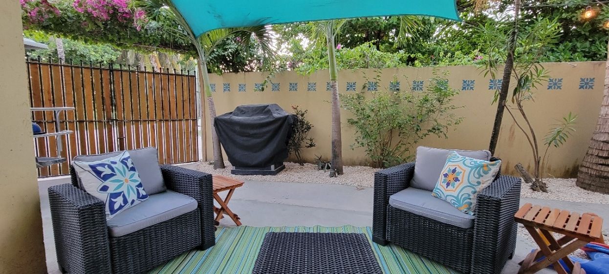 A patio with two chairs and a table under an umbrella.