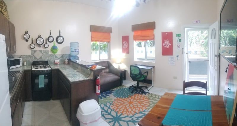 A kitchen with a stove , refrigerator , table and chairs.