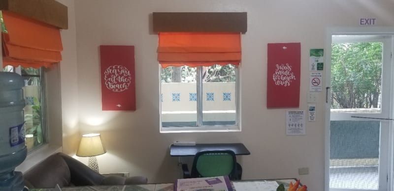 A living room with a couch , desk , lamp and window.