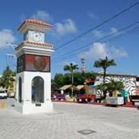 There is a clock tower in the middle of the street.