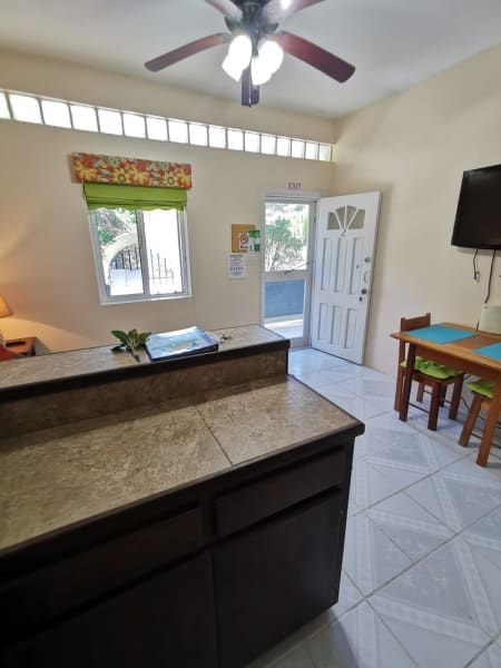 A kitchen with a table and chairs and a ceiling fan