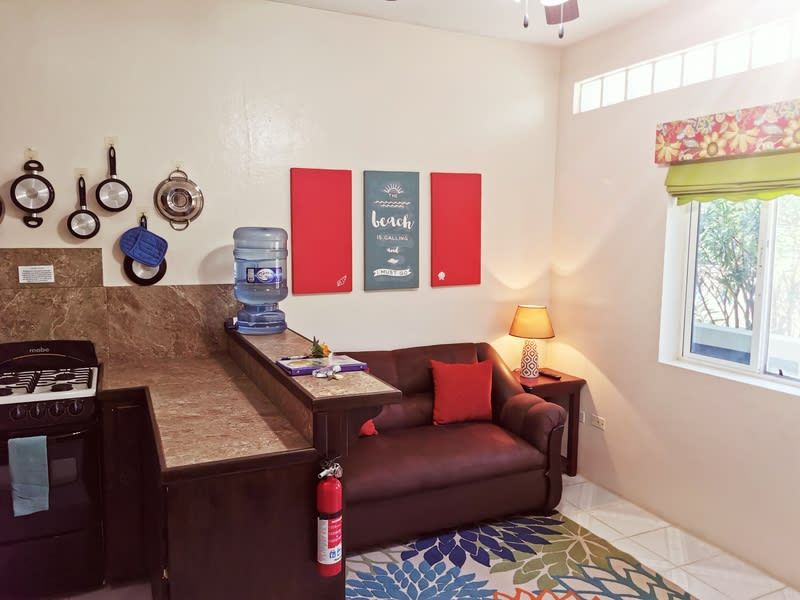 A kitchen with a couch and a fire extinguisher