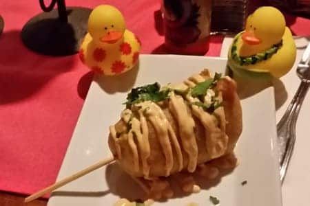 A white plate topped with food and rubber ducks on a table.