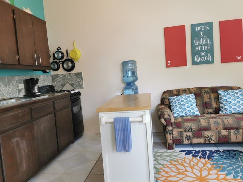 A kitchen with a couch and a sign that says life is better at the beach