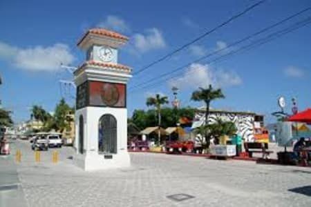 There is a clock tower in the middle of the street.