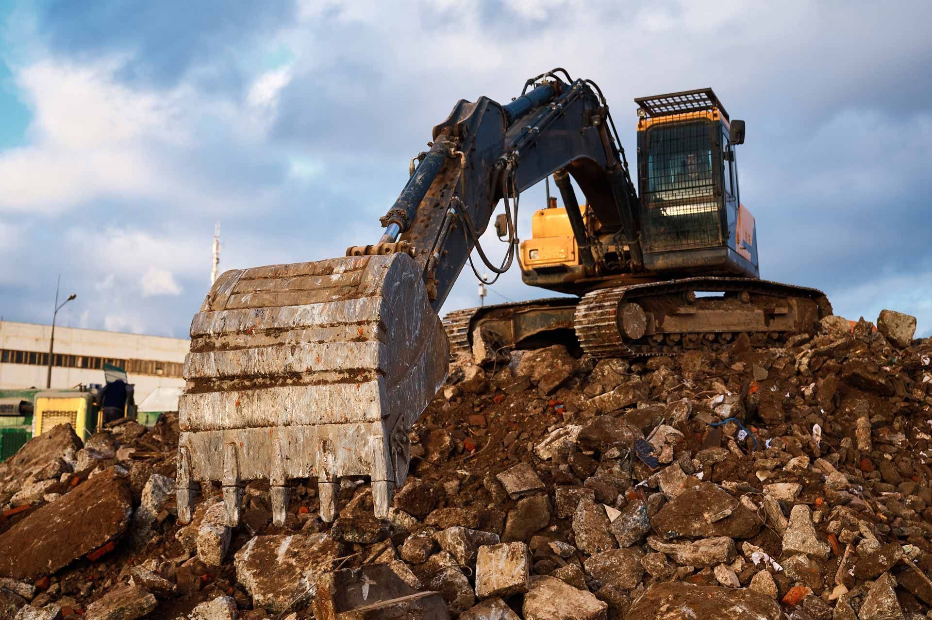 A bulldozer is digging into a pile of rocks.