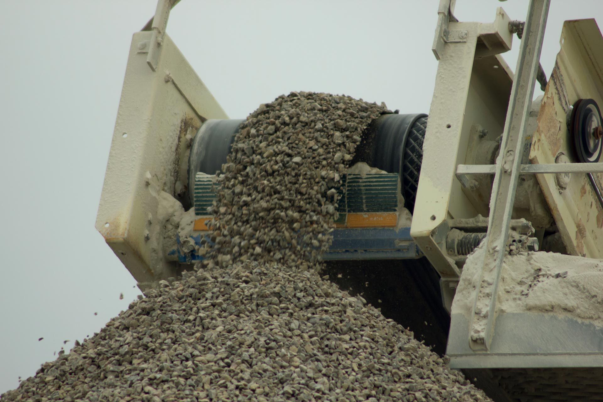 A pile of gravel is being loaded onto a truck