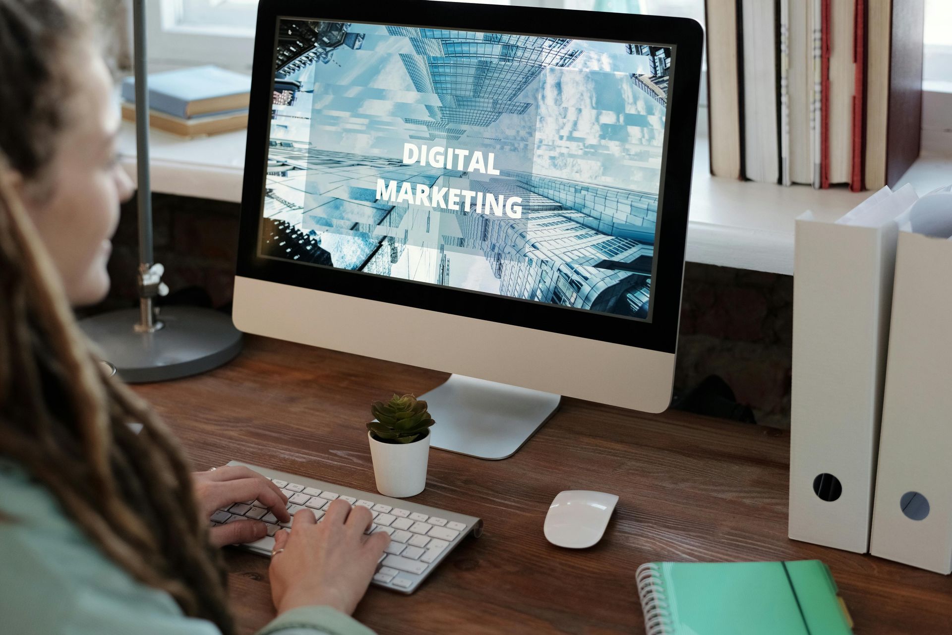 Person working at a desk with an iMac showing “Digital Marketing” on screen at Wilsona Marketing