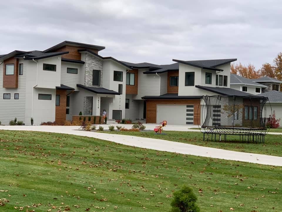 A row of houses are sitting next to each other on a lush green lawn.