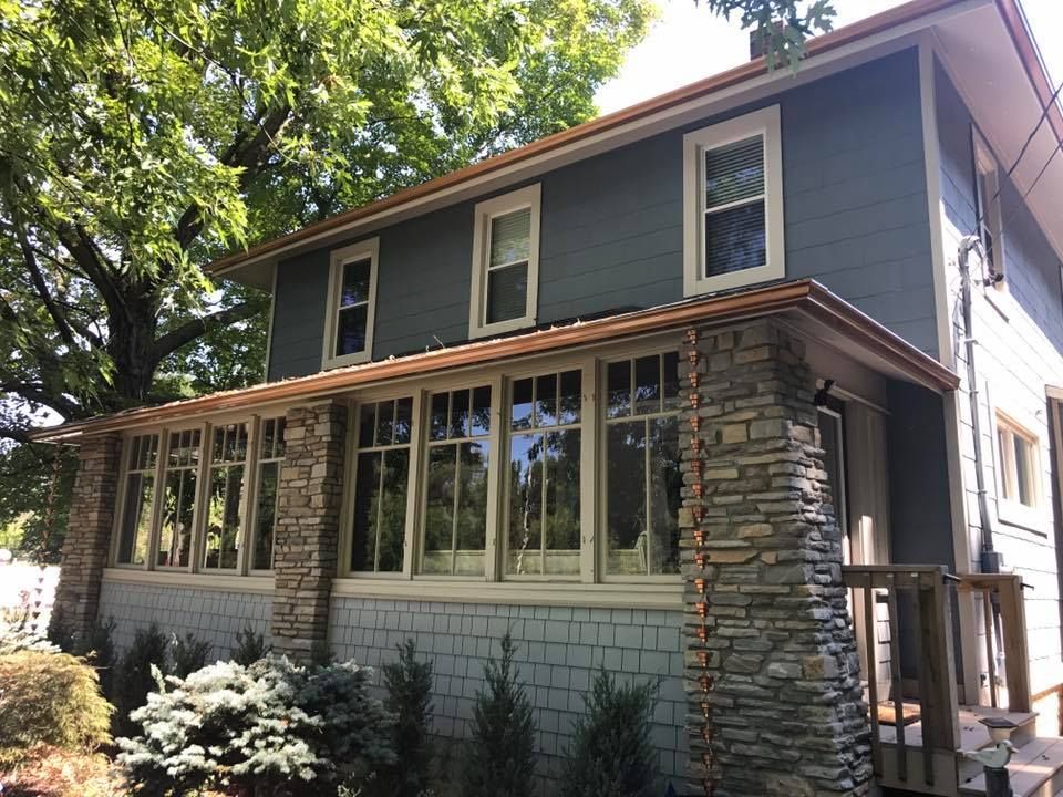 A house with a stone porch and lots of windows