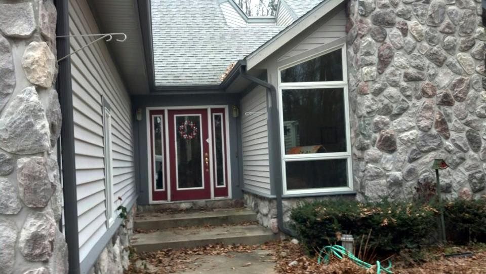 A house with a red door and a stone wall