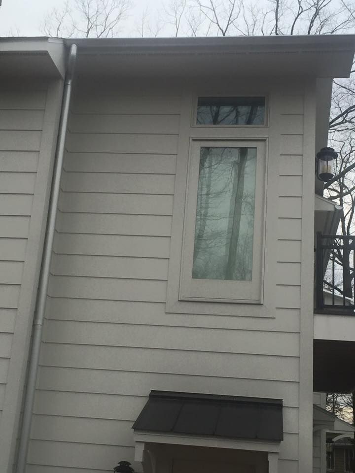 A white house with a window and a gutter on the side.