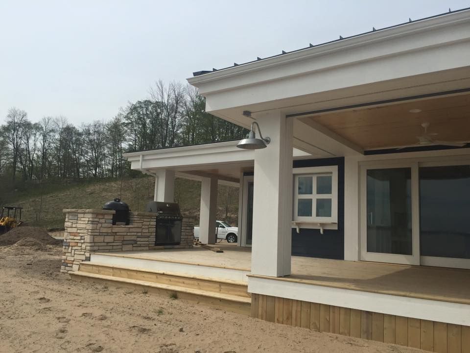 A house with a covered porch and a grill