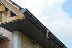 A gutter is being installed on the side of a building.