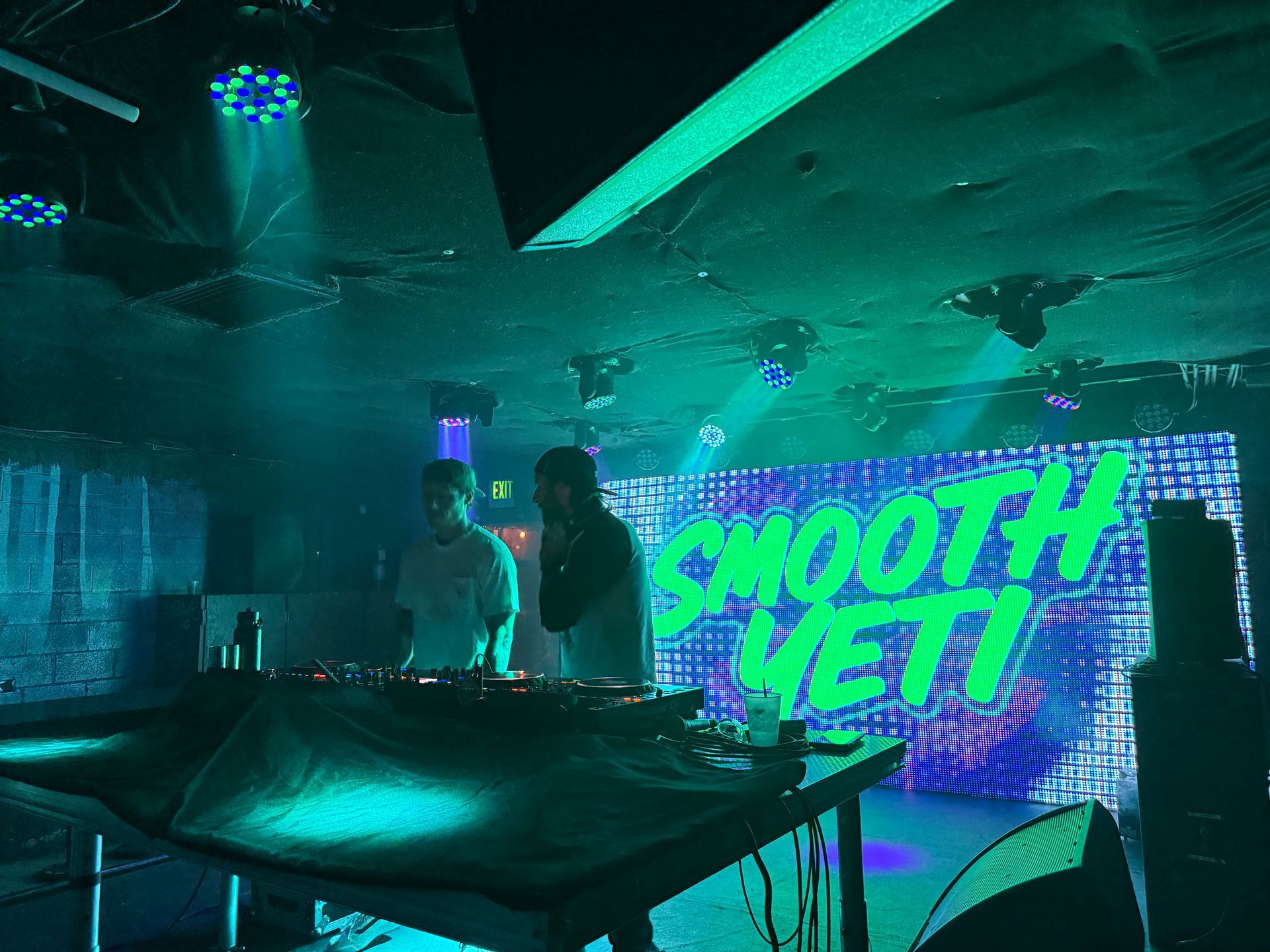 Two people DJing at a club with a 