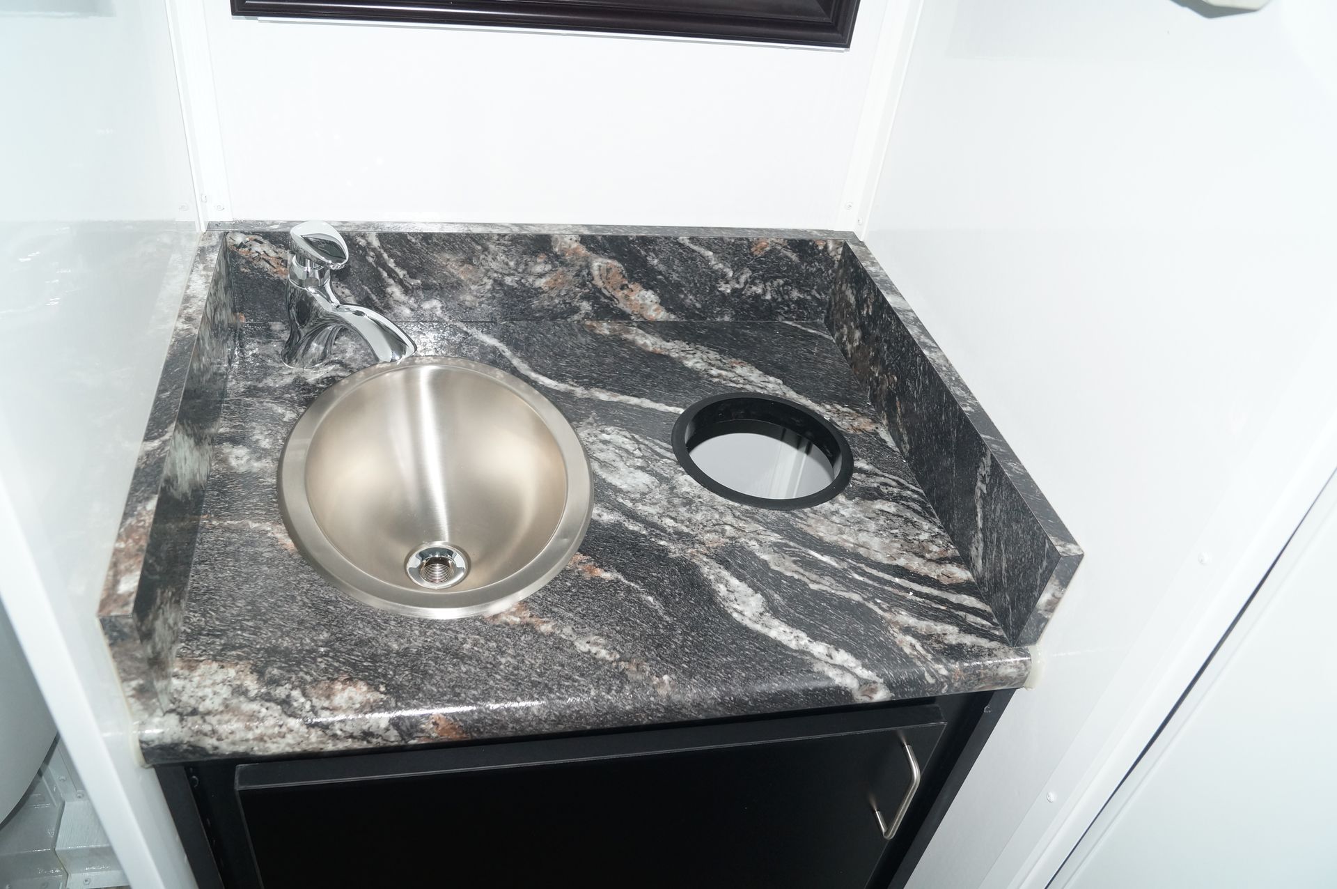 a bathroom counter with a sink and a trash can .