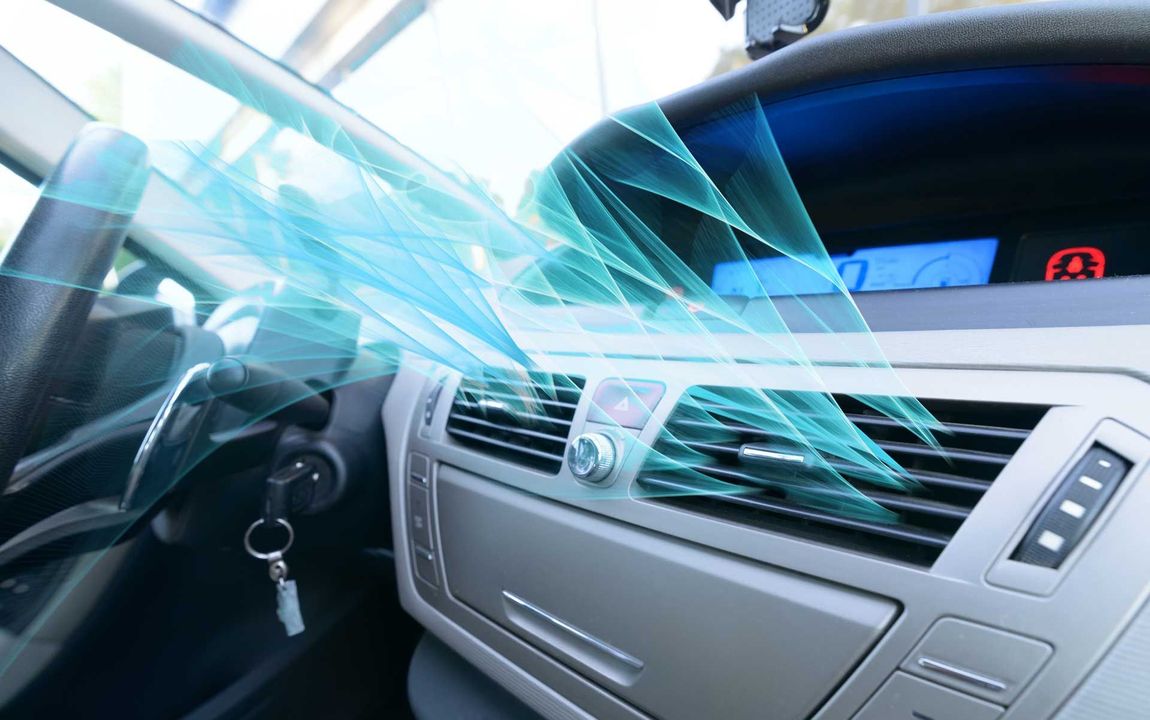 Car dashboard with blue airflow lines showing air conditioning vents and controls