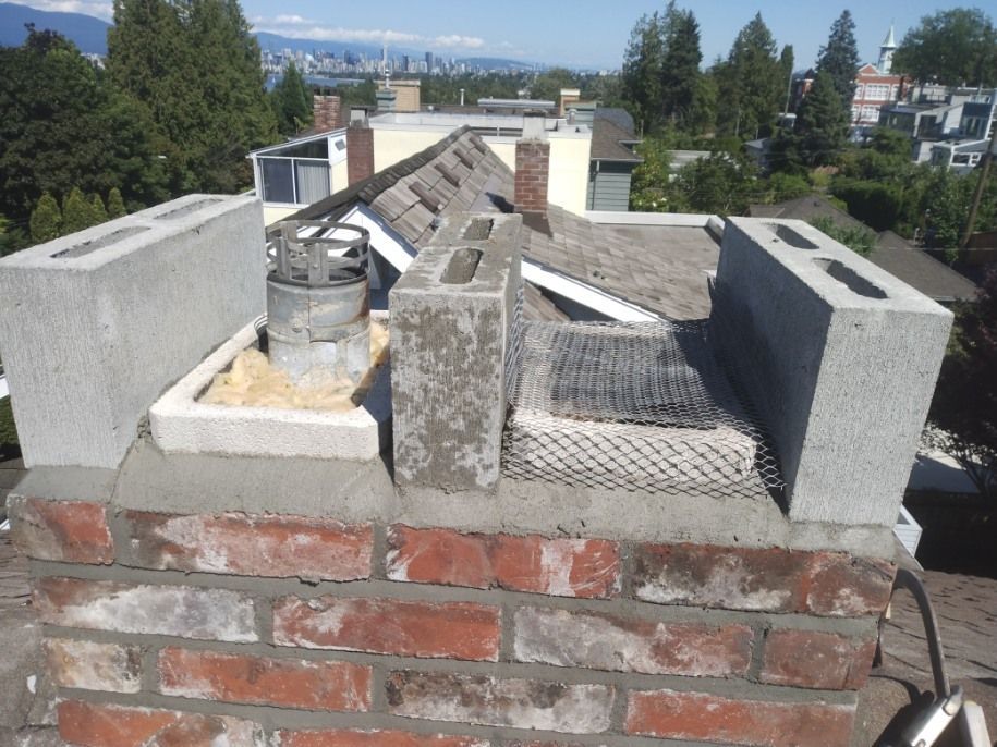 A brick chimney on top of a roof with a city in the background