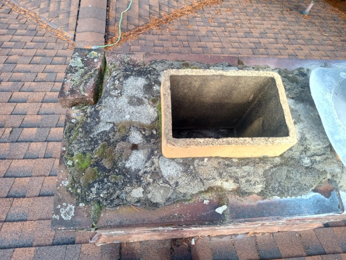 A chimney is sitting on top of a brick roof.