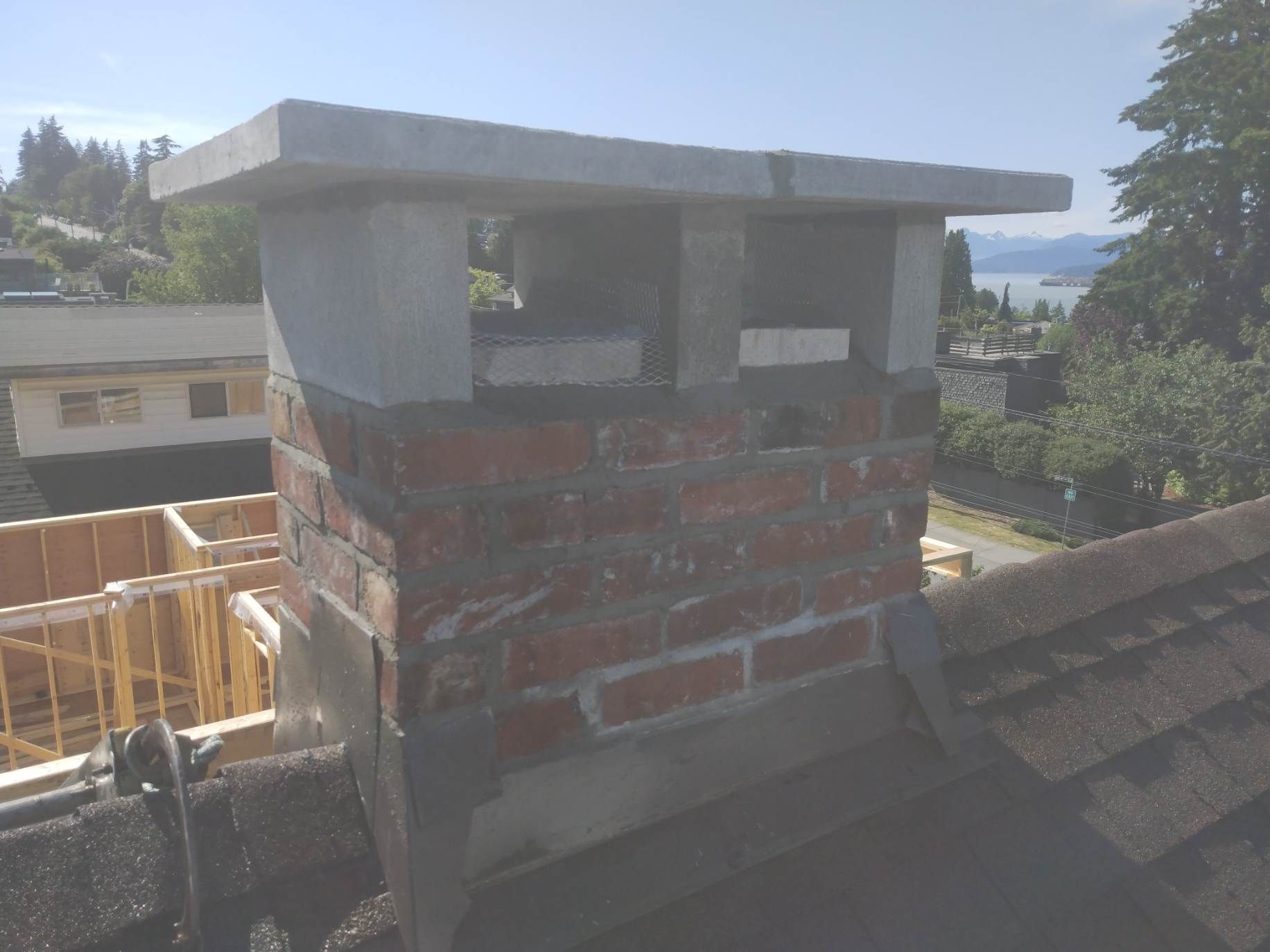 A brick chimney is sitting on top of a roof