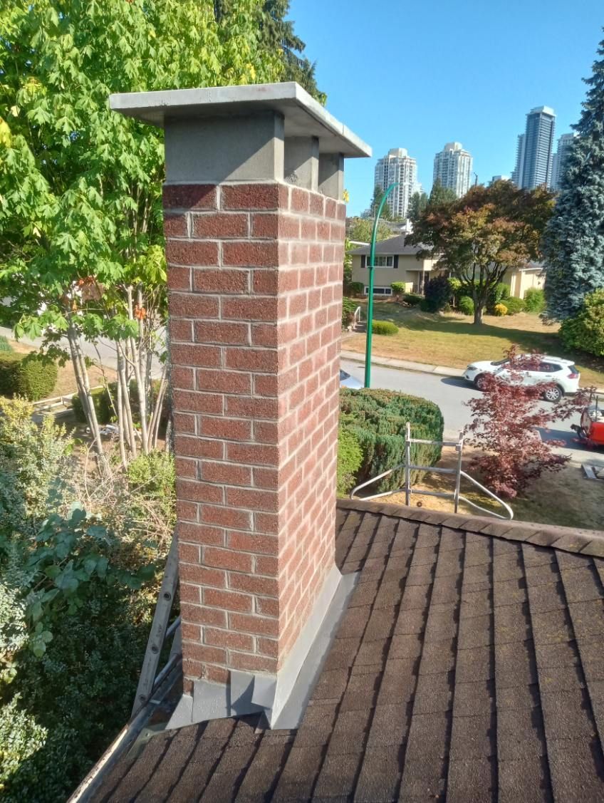 A brick chimney on top of a roof with a city in the background